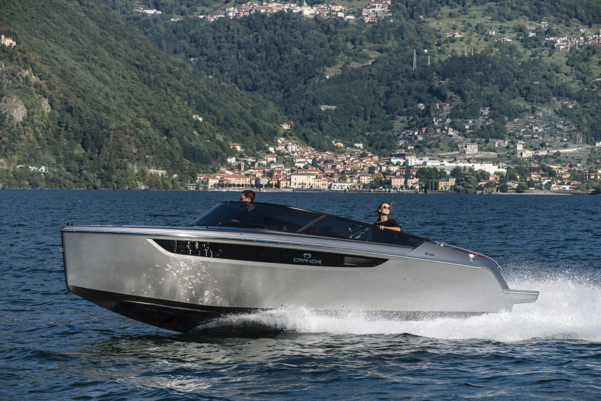 Cranchi E26 Classic in navigazione davanti a un borgo sul lago